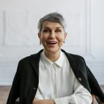 Confident woman smiling in an office, ideal for professional themes.